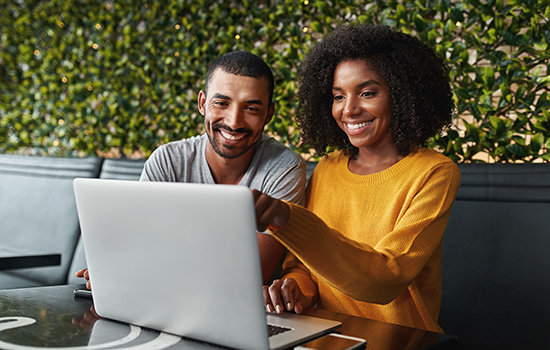 young couple in café looking at laptop