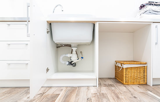 under the sink in laundry room