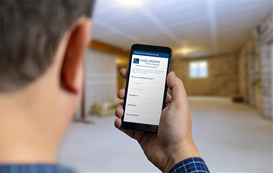 over the shoulder view of man using lead Service Line Survey form in home basement